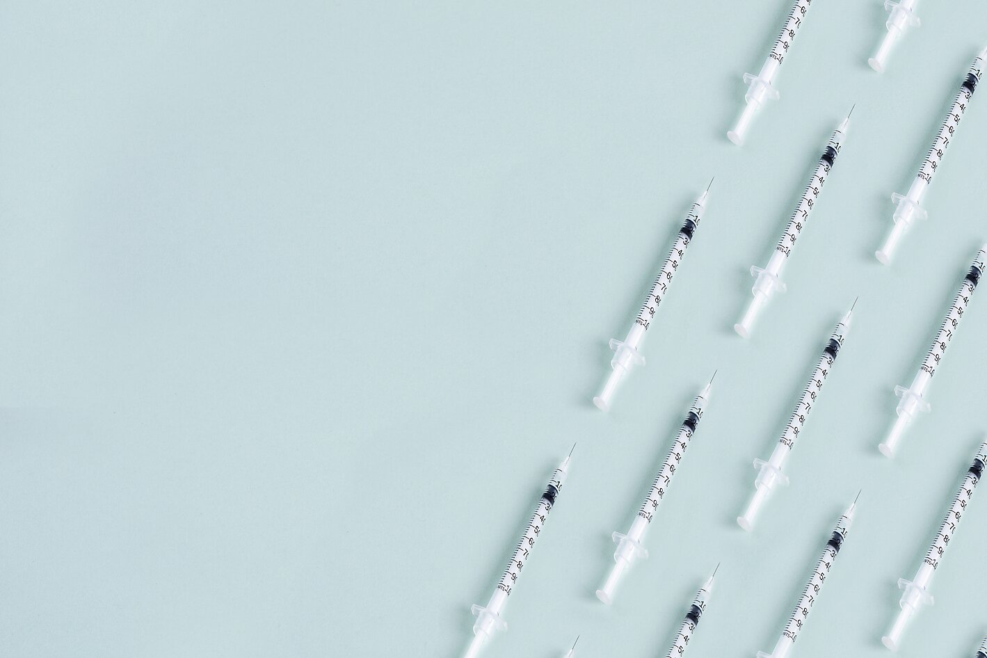 Syringe pattern on blue background with copy space.