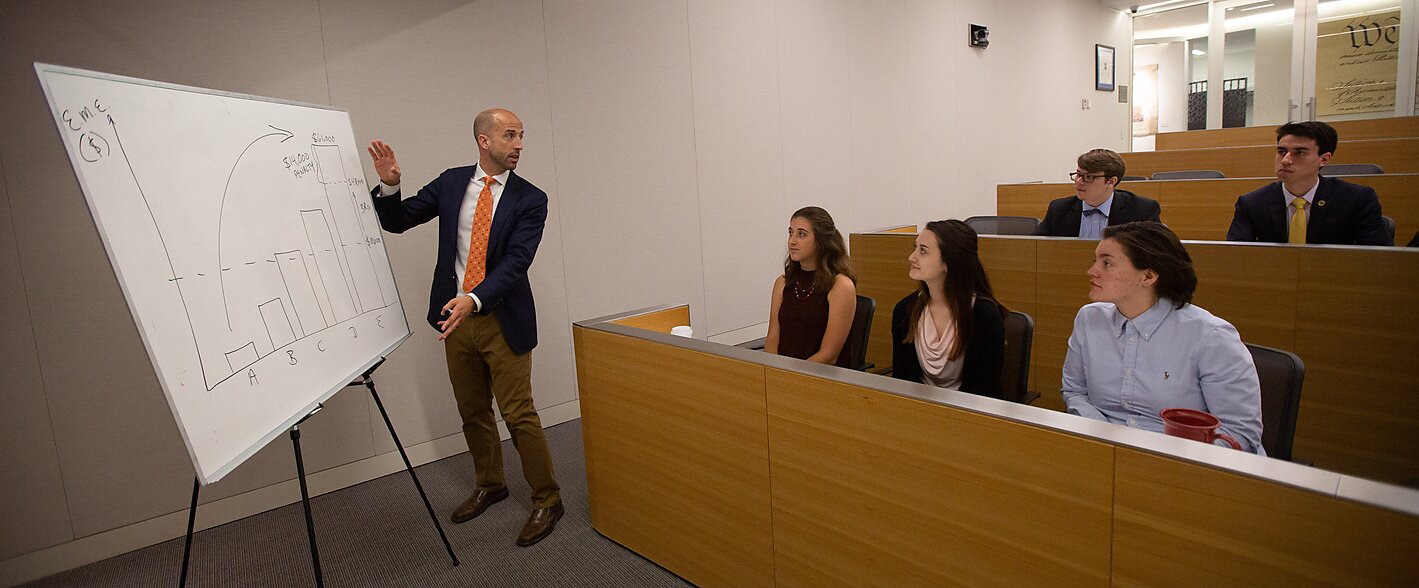 Presentation being given by scholar to a small group of interns