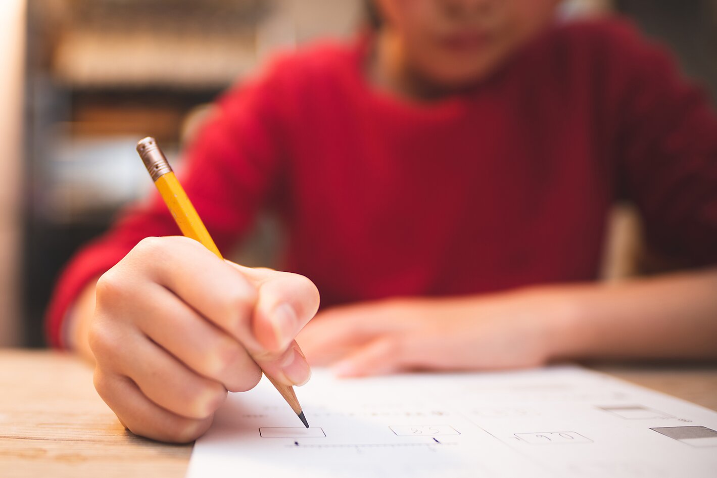 Hands of a child studying at desk 