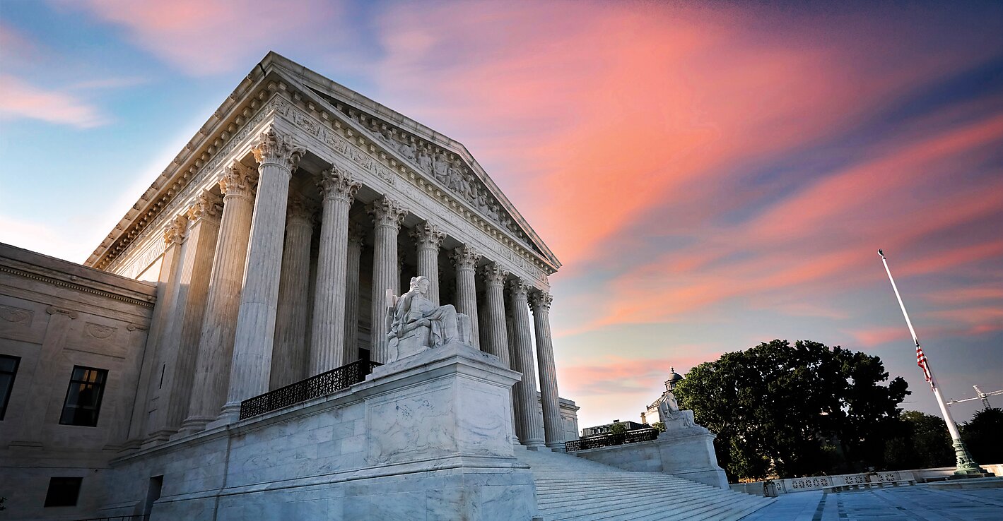 Supreme Court against a sunset sky.