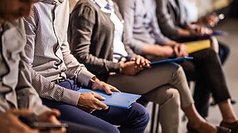Professionals seated with folders on their laps waiting