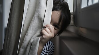 Boy playing hide-and-seek at home