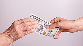 Hands Holding Money Representing Generational Transfer of Wealth