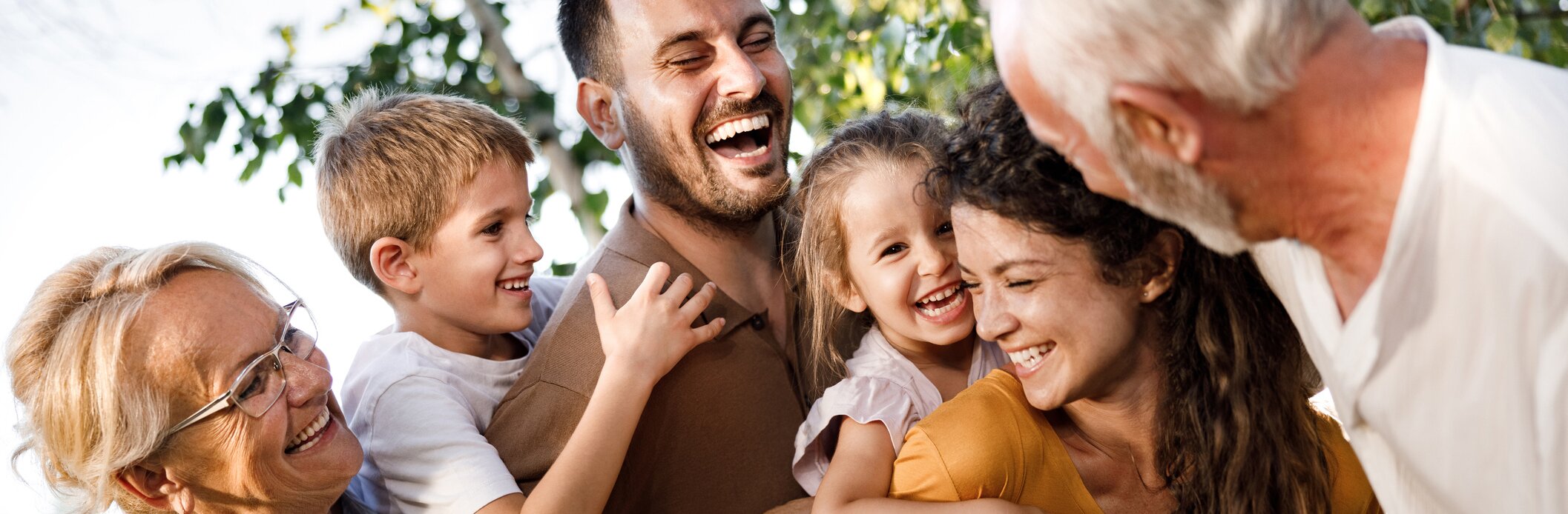 An intergenerational family smiling and laughing together.