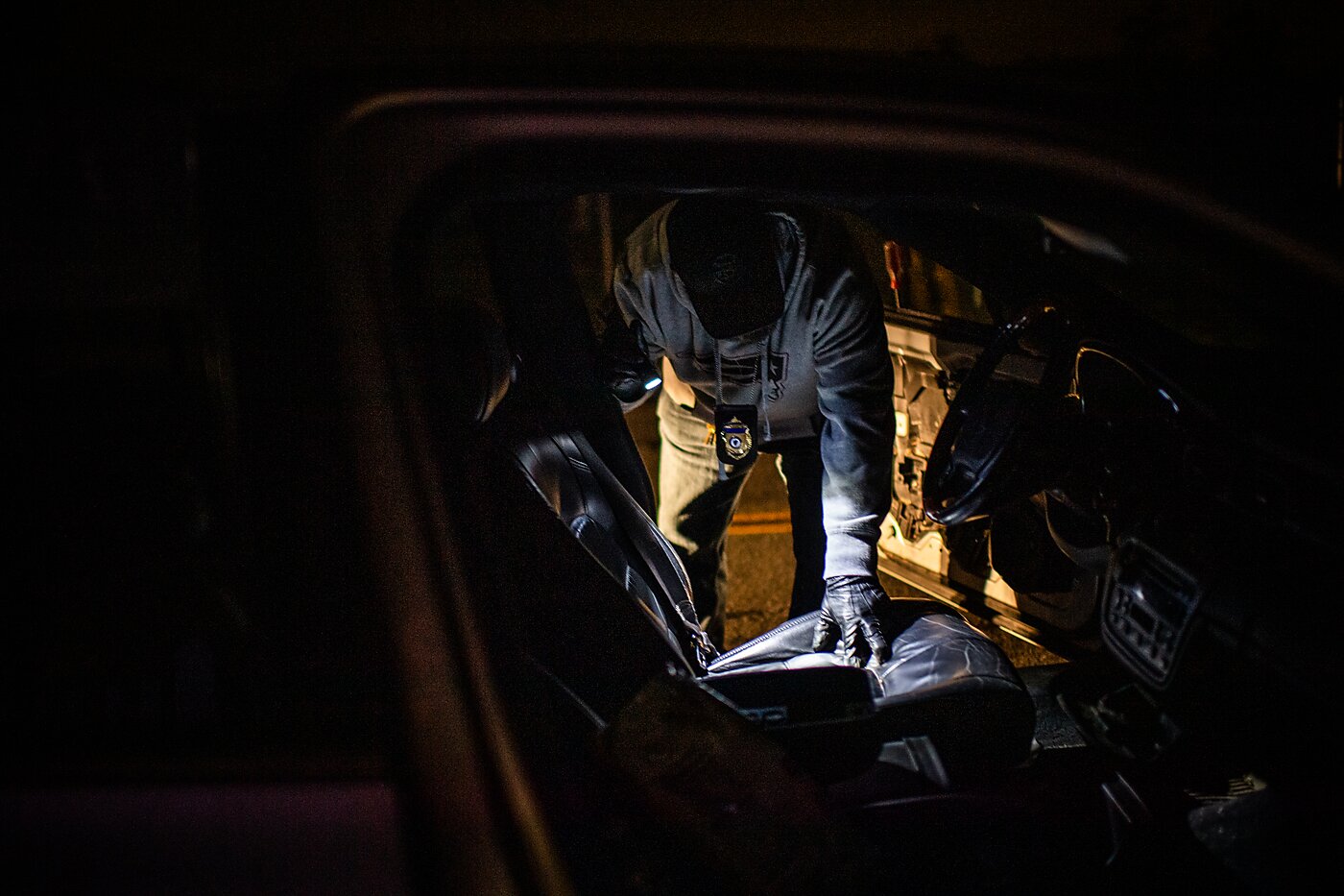 A police officer searches a car