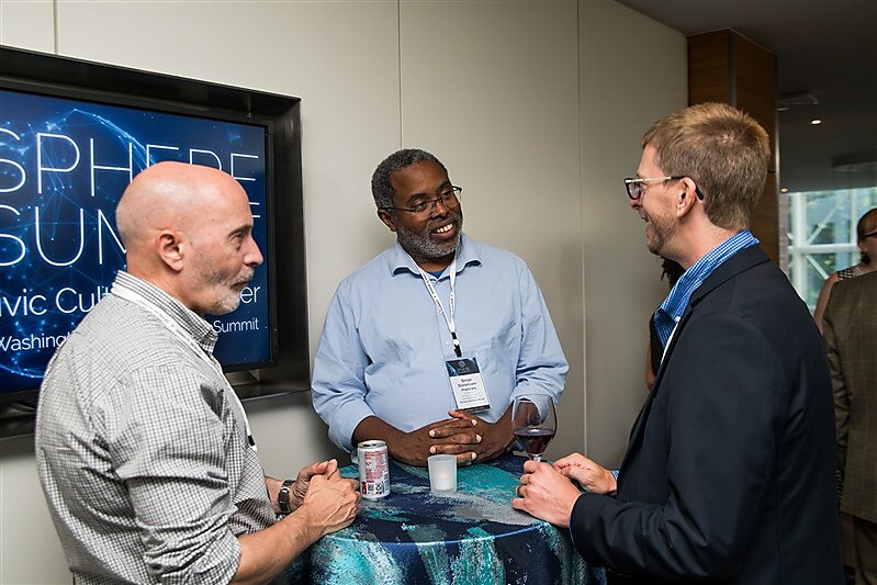 Sphere Summit attendees engage in a discussion during a break.
