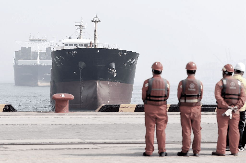  Dockworkers wait for cargo ships to berth at the general cargo terminal of Qianwan Port in Qingdao, east China's Shandong Province, March 2023.