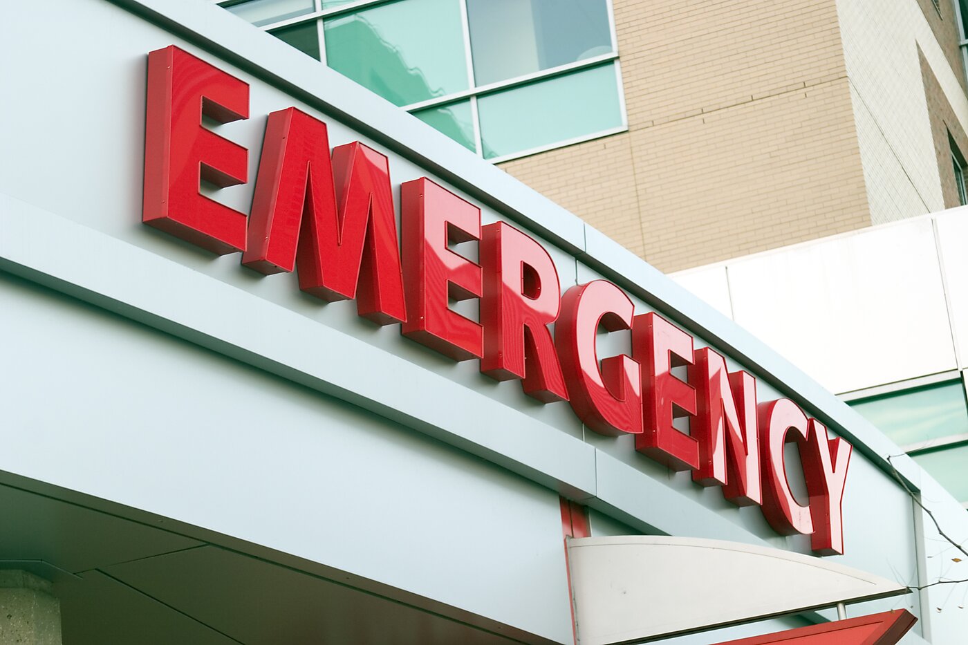 Sign shows the word emergency in red lettering