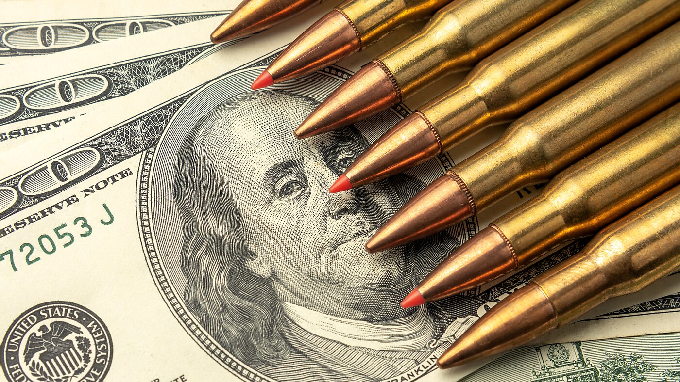 Bullets scattered on top of $100 bills