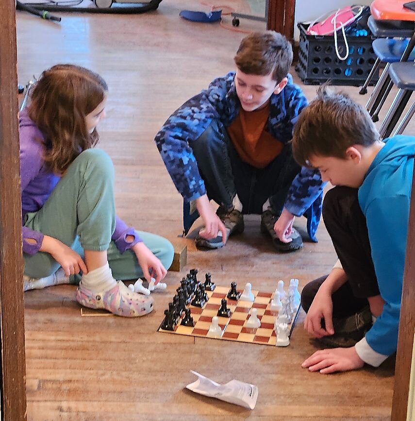 Students playing chess at Eyes and Brains STEM Center.